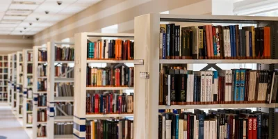 Dwoje uczniów czytających książki przy stole w bibliotece — zdjęcie ilustracyjne