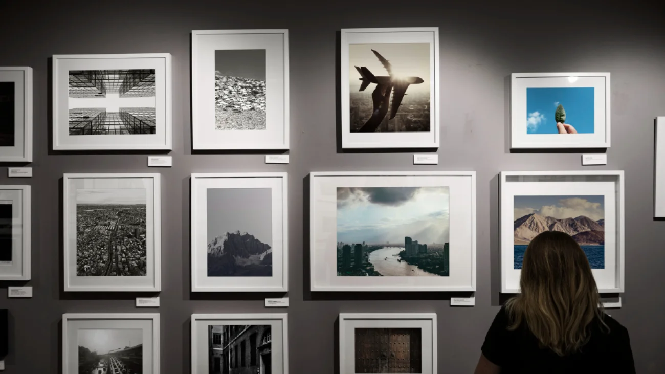 Kobieta oglądająca fotografie na ścianie galerii — zdjęcie ilustracyjne