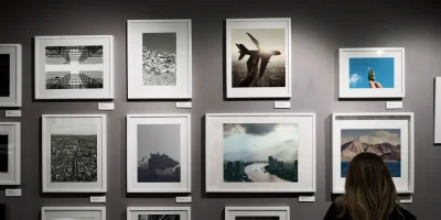 Kobieta oglądająca fotografie na ścianie galerii — zdjęcie ilustracyjne